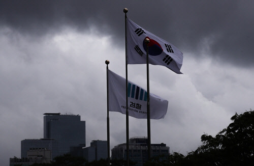 서울 서초동 검찰 청사에 펄럭이는 깃발 너머로 삼성 서초사옥(왼쪽 아래)의 모습이 보이고 있다. <연합뉴스 제공>